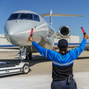 airport fbo employee waving jet in right direction