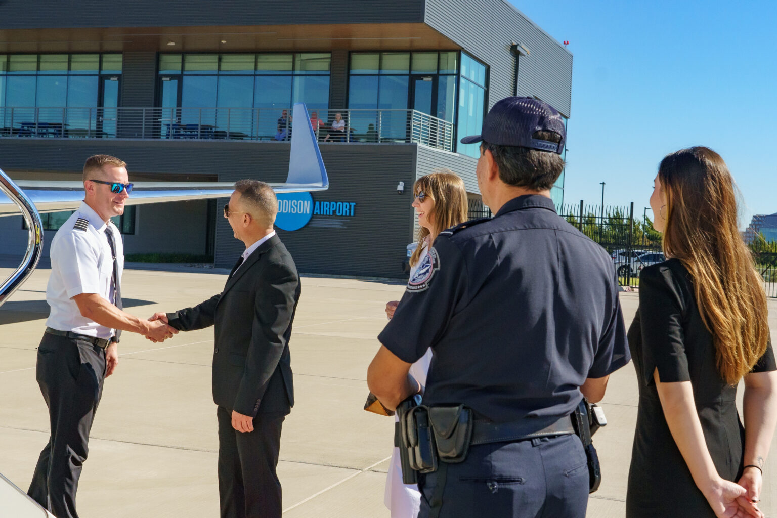 pilot shaking hands with man in suit at addison airport