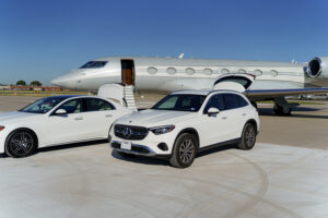 two luxury vehicles in front of private jet on the tarmac